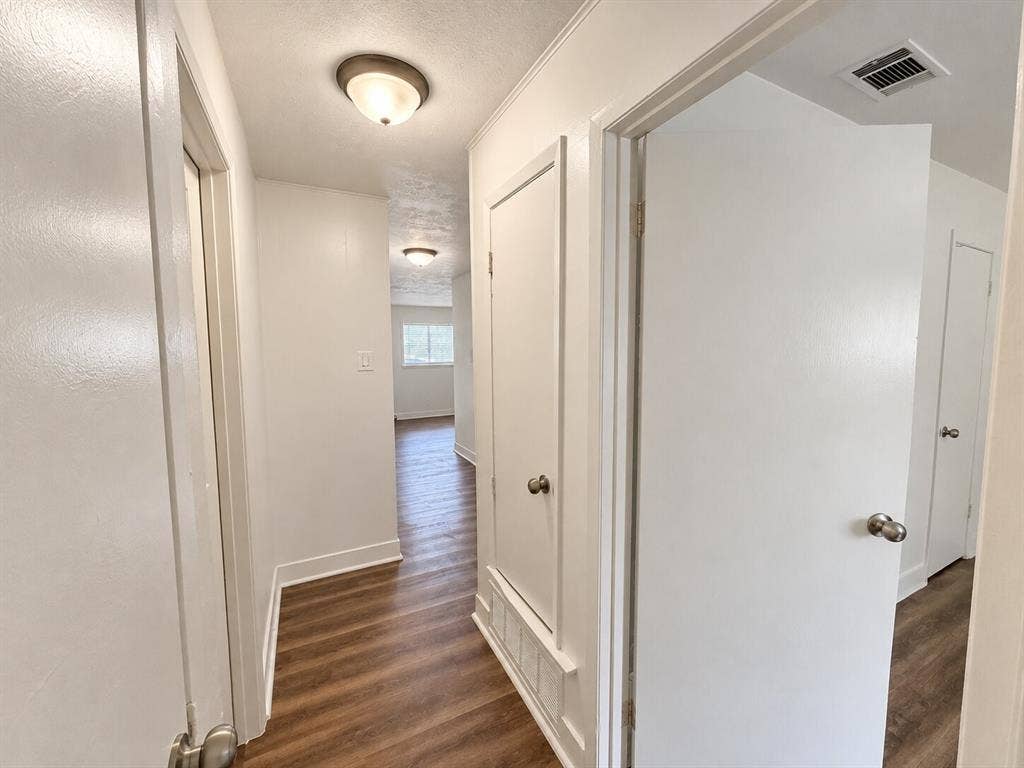 2002 Washington Street, #3, Commerce, TX 75428 Hallway featuring wood-finish flooring, white walls, and flush-mount lighting fixtures