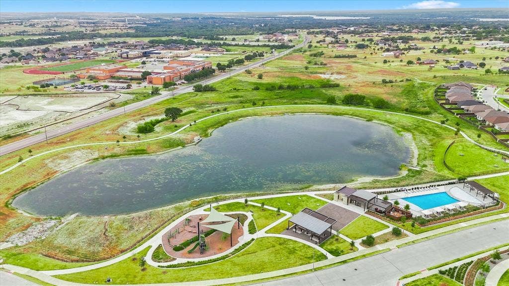 Community lake with surrounding green spaces, playground area, and aquatic center featuring a swimming pool