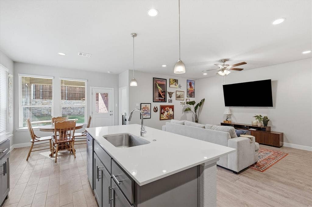 Open-concept living space with wood-finish flooring, recessed lighting, and a ceiling fan