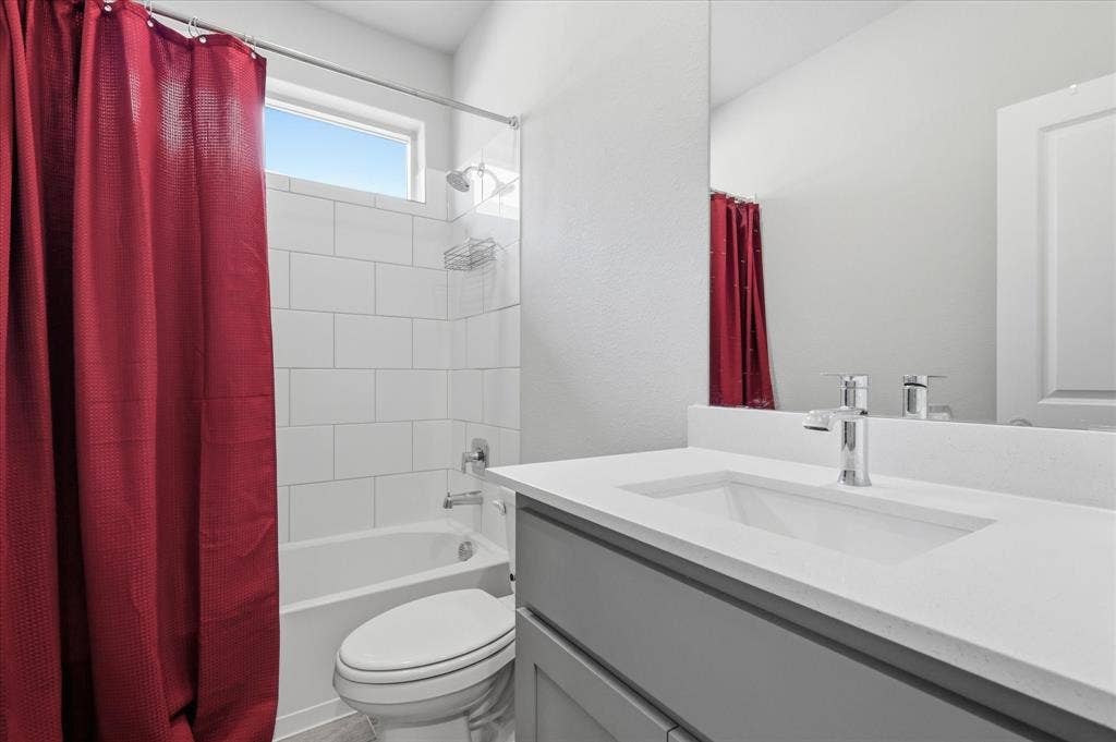 Tub-shower combination with subway tile surround, sleek vanity with integrated sink, chrome fixtures, and a transom window