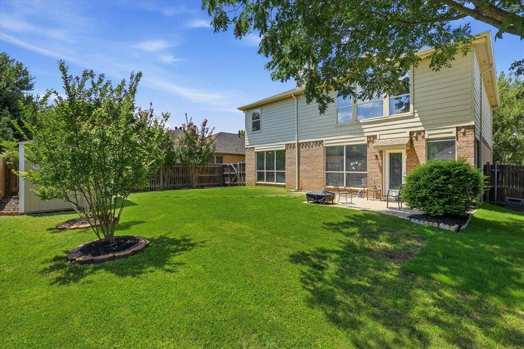2112 Loon Lake Road, Denton, TX 76210 Expansive green lawn, mature trees, privacy fencing, outdoor patio, and a storage shed