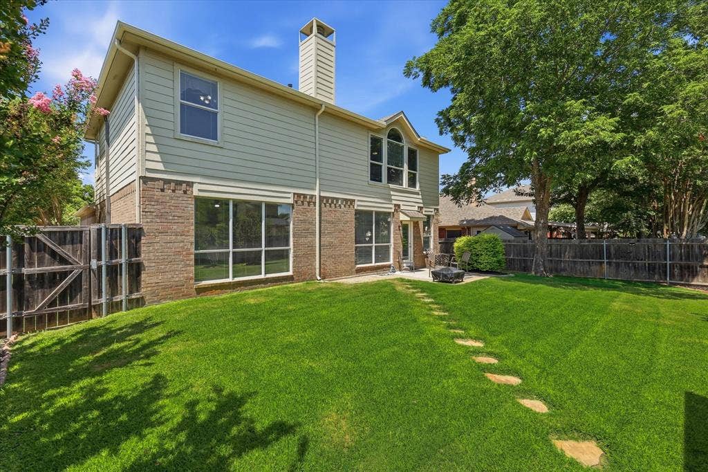 2112 Loon Lake Road, Denton, TX 76210 Expansive backyard with a manicured lawn, stone pathway, and mature trees
