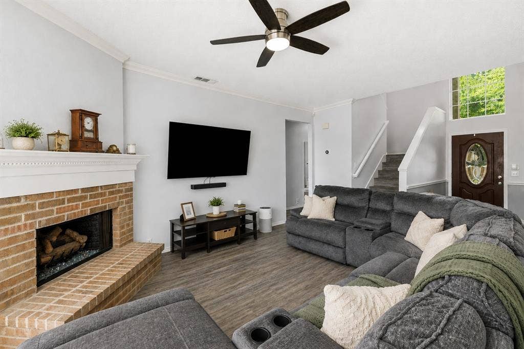 2112 Loon Lake Road, Denton, TX 76210 Brick fireplace with a white mantel, wood-finish flooring, and a ceiling fan with integrated lighting