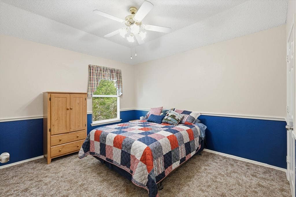 2112 Loon Lake Road, Denton, TX 76210 Textured carpet flooring, window with natural light, two-tone wall finish, and a ceiling fan with integrated lighting