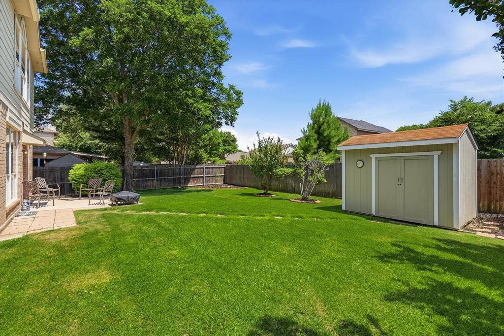 2112 Loon Lake Road, Denton, TX 76210 Expansive green lawn with a paver patio and a separate storage shed