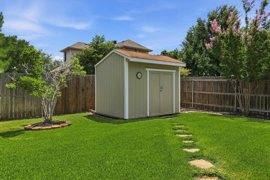 2112 Loon Lake Road, Denton, TX 76210 Expansive backyard with a storage shed, wood privacy fencing, and stepping stone pathway