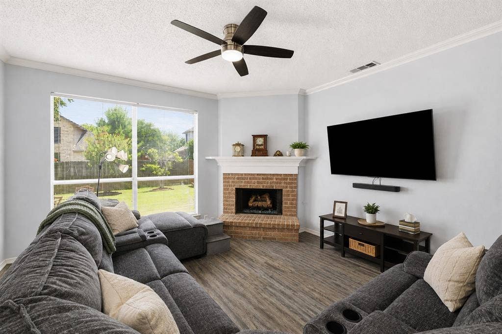 2112 Loon Lake Road, Denton, TX 76210 Living area featuring wood-finish flooring, a brick fireplace with a white mantel, and large windows