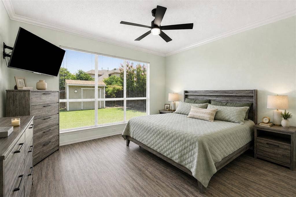 2112 Loon Lake Road, Denton, TX 76210 Wood-finish flooring, large multi-pane window, ceiling fan with integrated lighting, crown molding, and light-toned wall paint