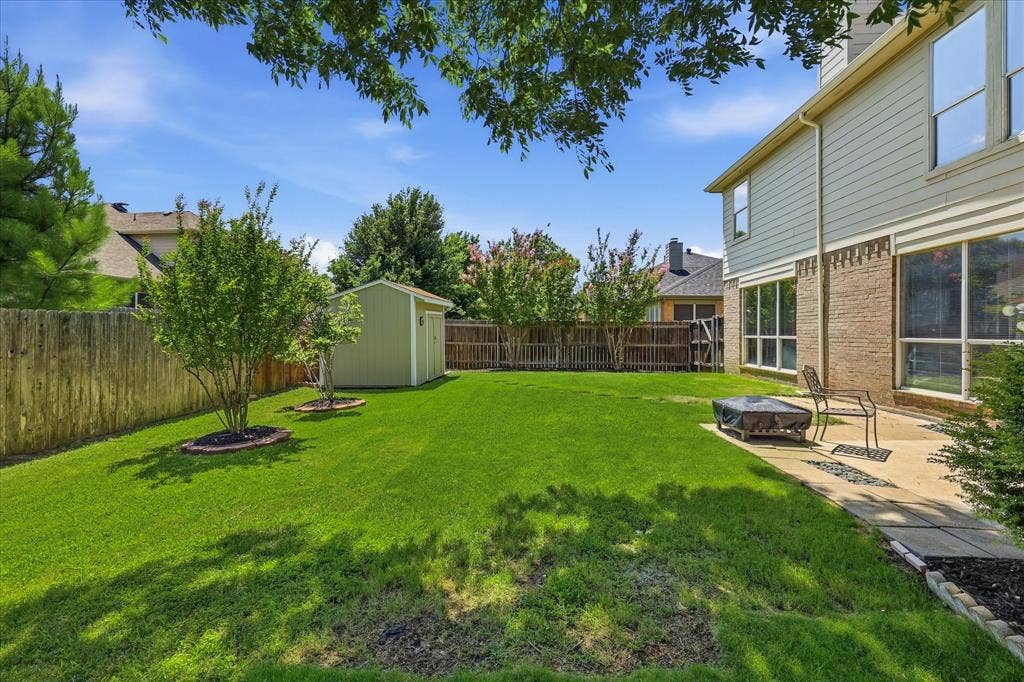 2112 Loon Lake Road, Denton, TX 76210 Expansive backyard with a manicured lawn, established trees, and a concrete patio