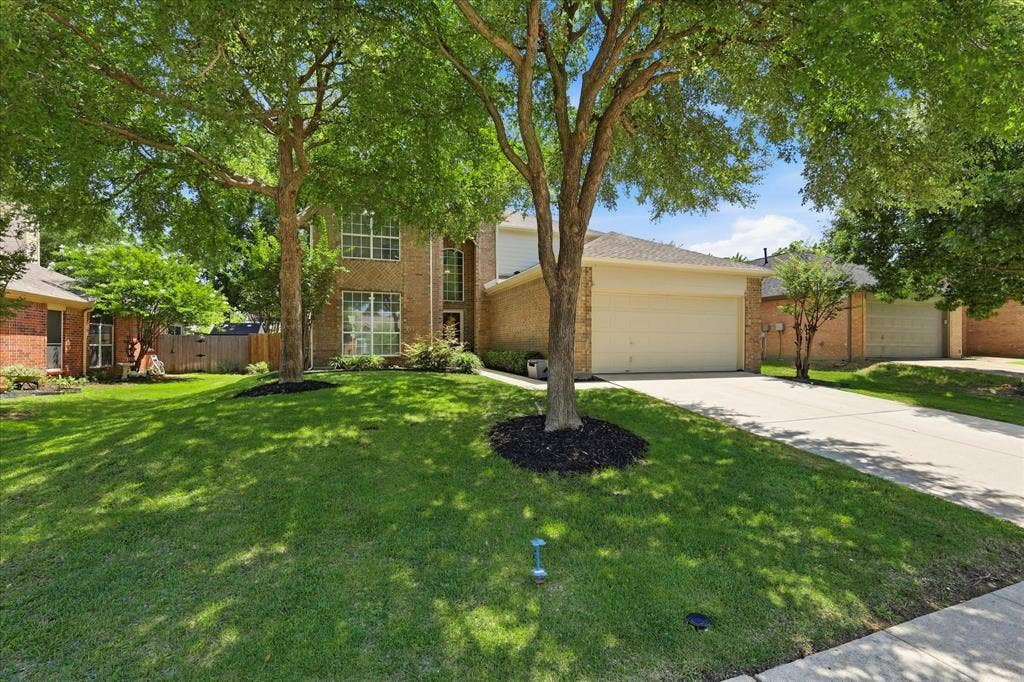 2112 Loon Lake Road, Denton, TX 76210 Brick exterior with multiple windows, attached garage, and a concrete driveway