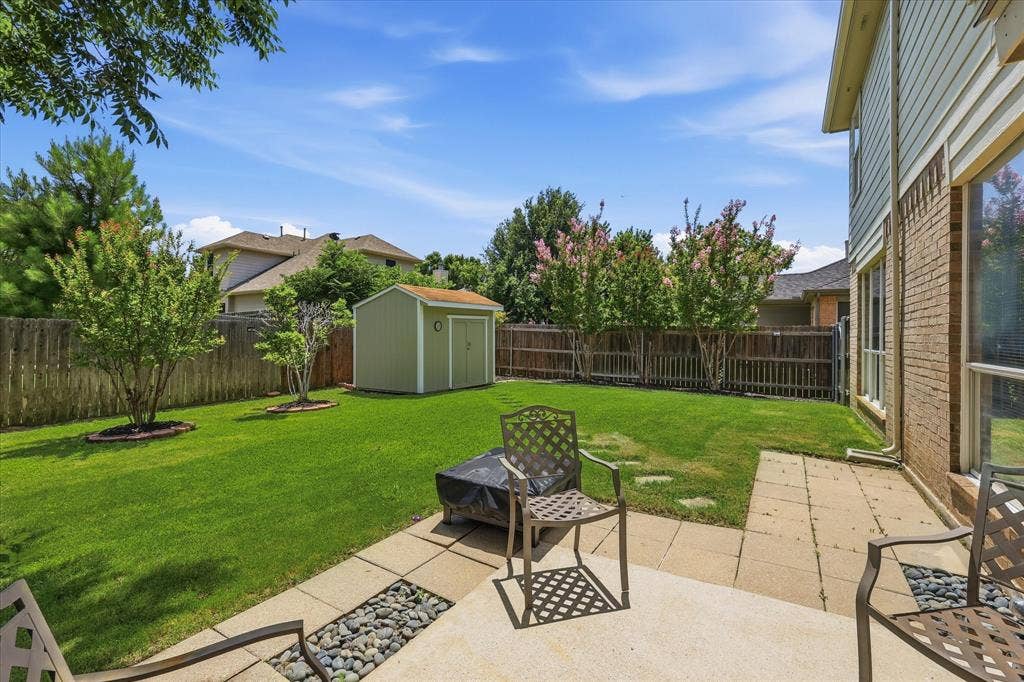 2112 Loon Lake Road, Denton, TX 76210 Expansive backyard featuring a lush lawn, a storage shed, and a privacy fence