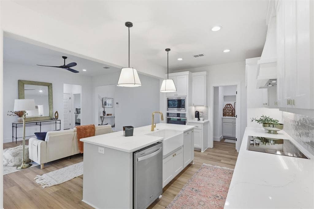 124 Norene Lane, Weatherford, TX 76088 Open-concept kitchen featuring white cabinetry, quartz countertops, a farmhouse sink, and stainless steel appliances
