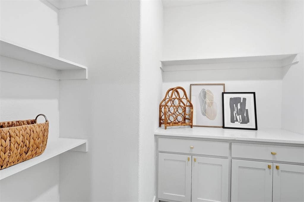 124 Norene Lane, Weatherford, TX 76088 White built-in shelving, white cabinets with gold-tone hardware, and white countertop