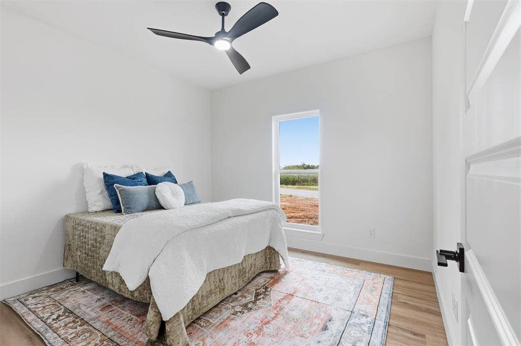 124 Norene Lane, Weatherford, TX 76088 Bright room featuring light-toned wood-finish flooring, a contemporary ceiling fan, and a single window with white trim