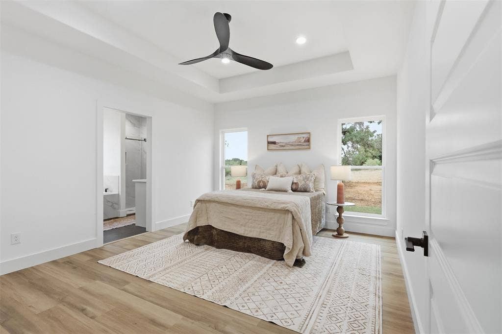 124 Norene Lane, Weatherford, TX 76088 Tray ceiling, wood-finish flooring, two windows, recessed lighting, and a contemporary ceiling fan