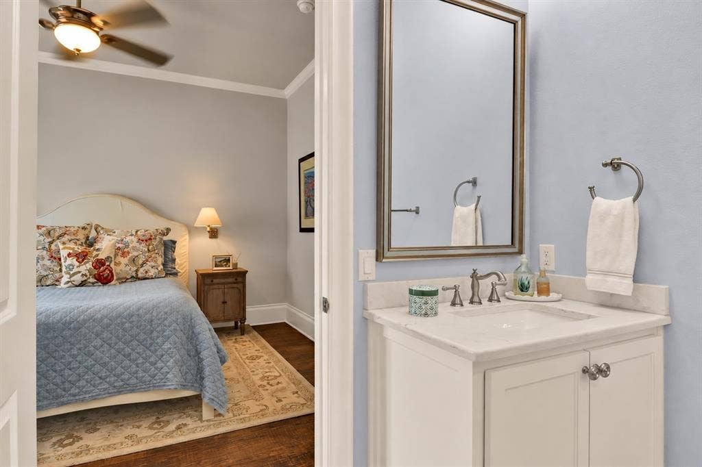 White vanity with an undermount sink, brushed nickel faucet, and a framed mirror