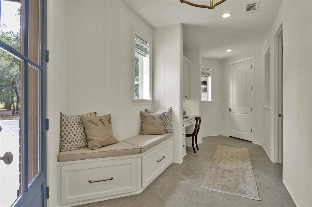 Built-in bench seating with storage drawers, paneling on walls, recessed lighting, and a transom window
