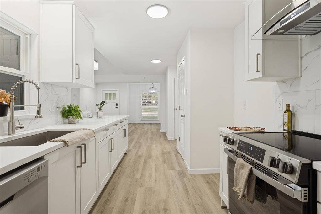 Modern kitchen with white cabinetry and stainless steel appliances