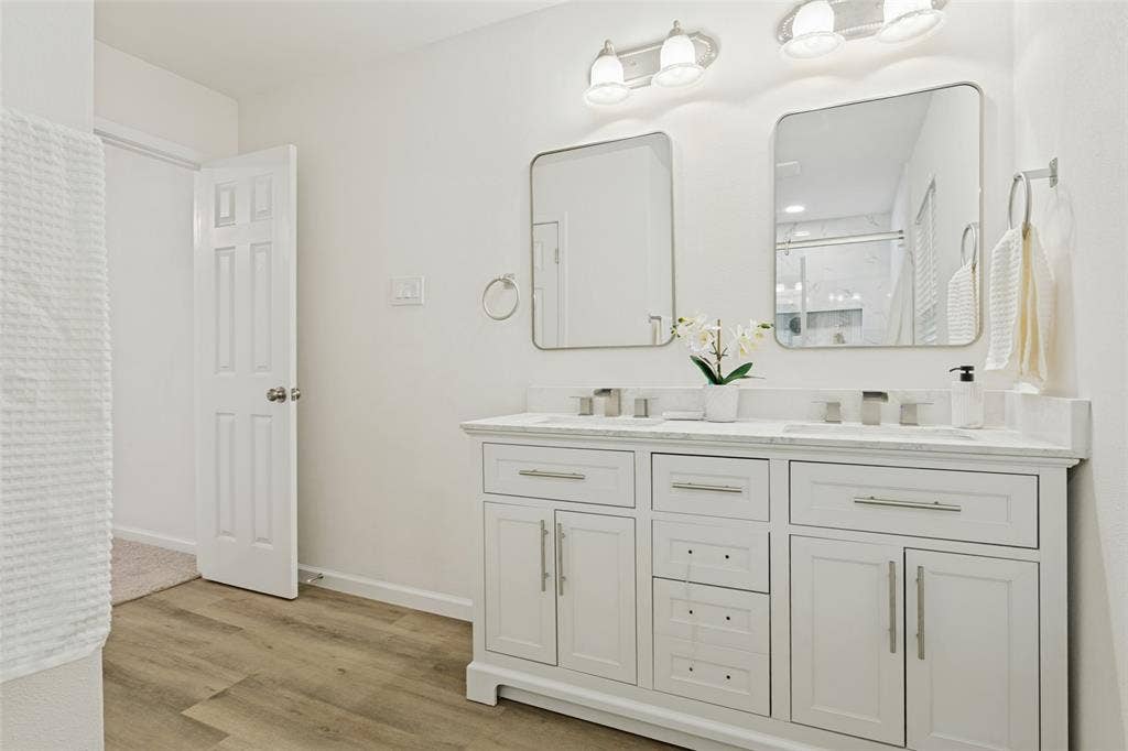 Dual vanity with white cabinetry, integrated sinks, and brushed nickel fixtures