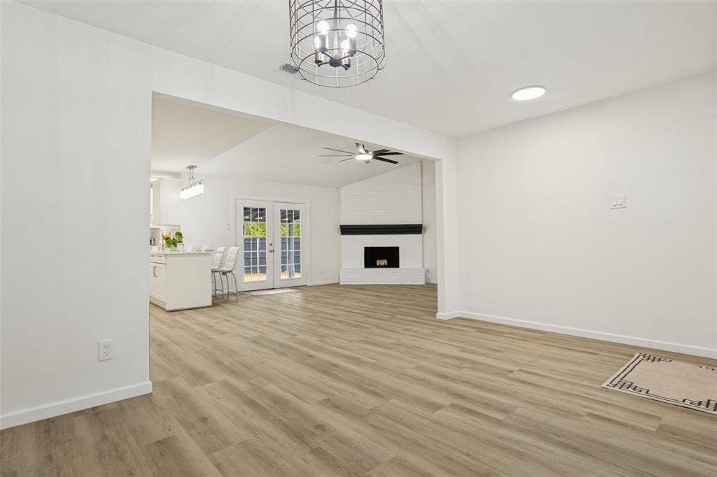 Wood-finish flooring throughout, recessed lighting, and a modern caged chandelier