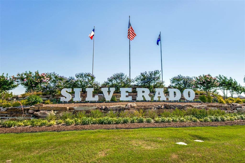 Sculpted landscaping with a prominent "Silverado" sign, three flagpoles, and manicured lawns