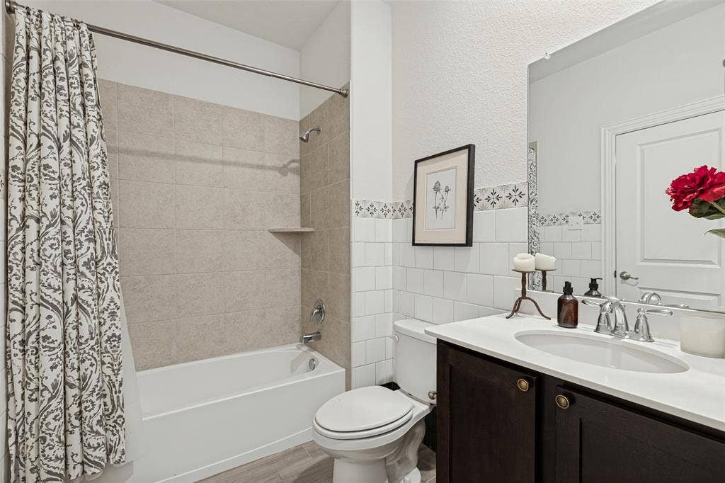 Bathtub with light-toned wall tile surround and integrated shelf
