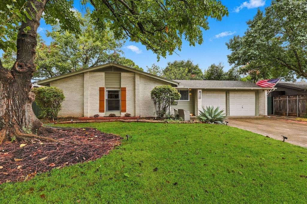 306 W Northgate Drive, Irving, TX 75062 Brick exterior with a gabled roof and attached two-car garage