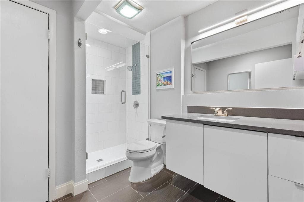 306 W Northgate Drive, Irving, TX 75062 Primary Walk-in shower with clear glass enclosure and tiled walls