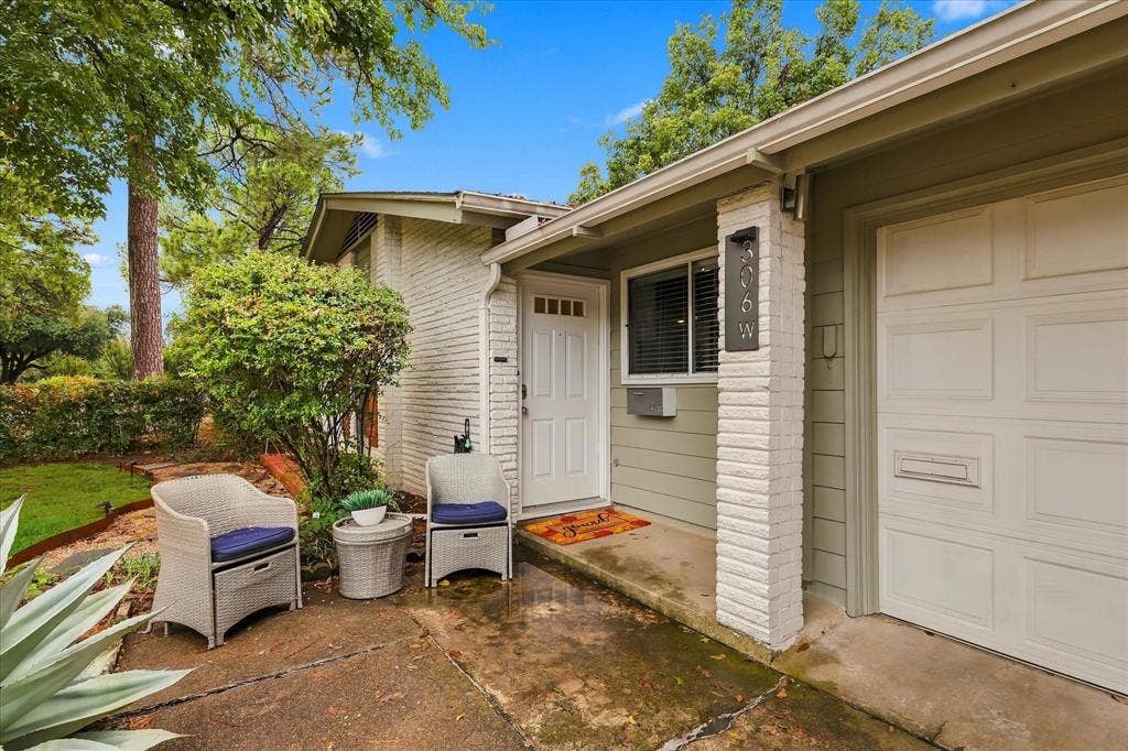 306 W Northgate Drive, Irving, TX 75062 White brick exterior with a light green siding accent