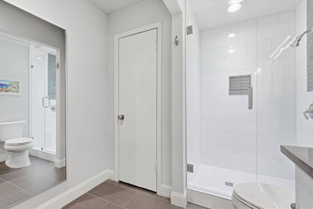 306 W Northgate Drive, Irving, TX 75062 Primary Walk-in shower with clear glass enclosure and subway tile surround
