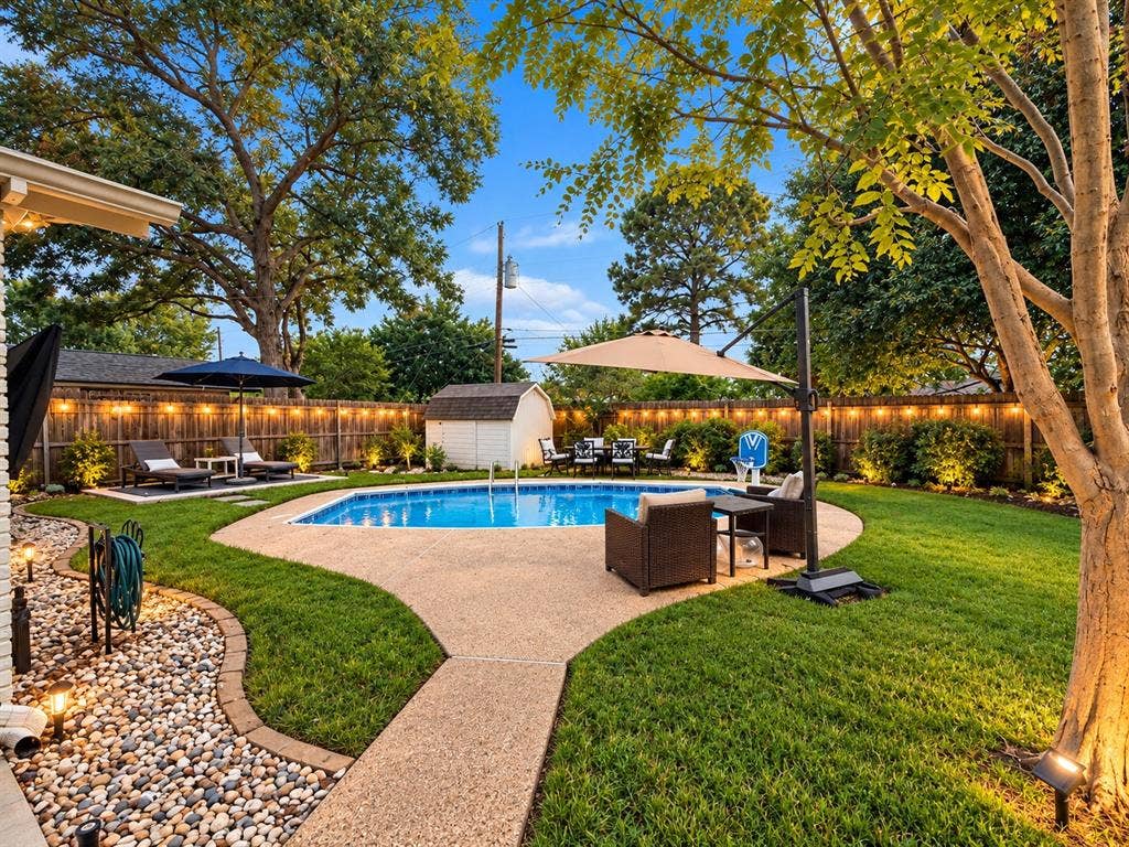 306 W Northgate Drive, Irving, TX 75062 Private backyard featuring a swimming pool, concrete patio, a storage shed, and mature trees