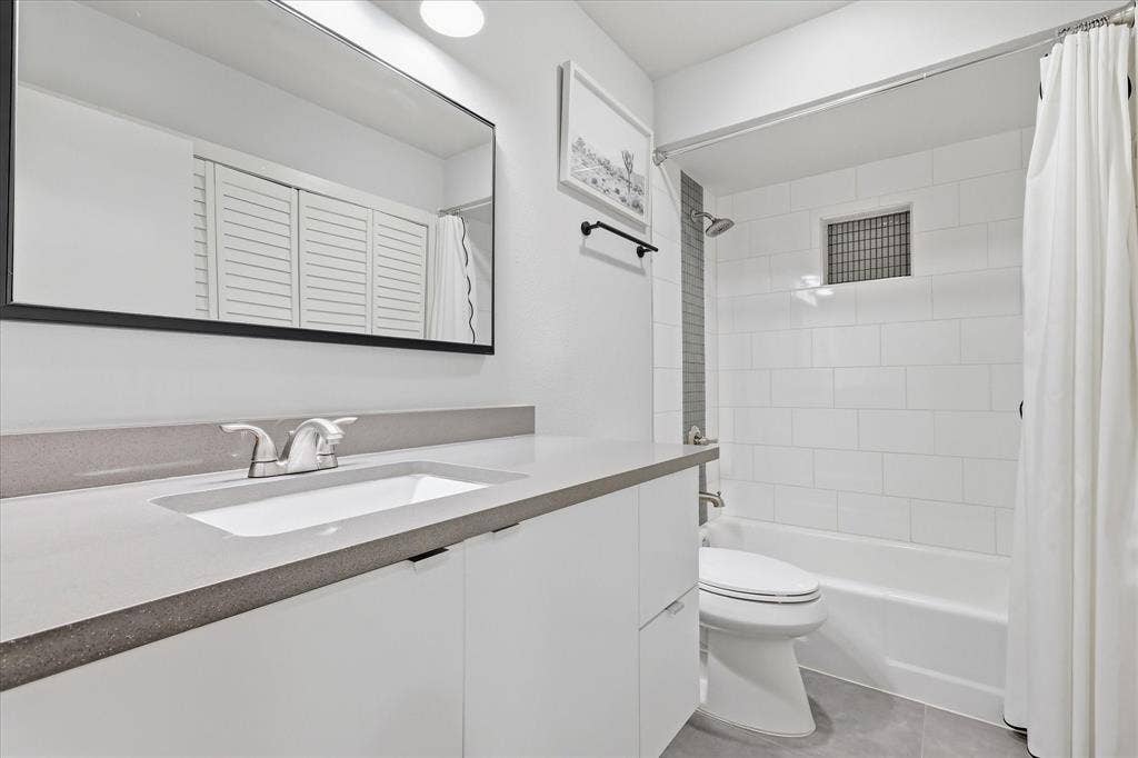 306 W Northgate Drive, Irving, TX 75062 Recessed lighting illuminates 2nd bathroom with a white vanity featuring a rectangular integrated sink and a gray quartz countertop