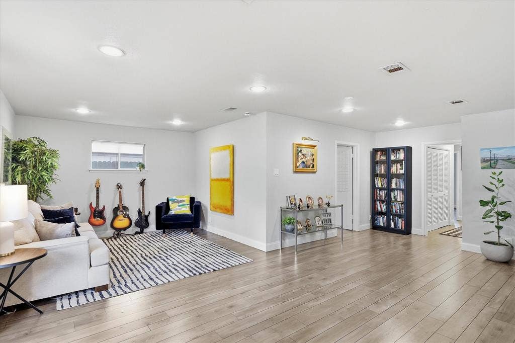 306 W Northgate Drive, Irving, TX 75062 Recessed lighting illuminates this expansive space featuring faux wood-finish flooring and light-toned walls