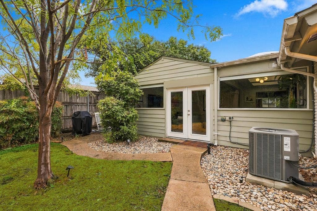 306 W Northgate Drive, Irving, TX 75062 Rear exterior with double-pane glass doors, horizontal siding, and an air conditioning unit