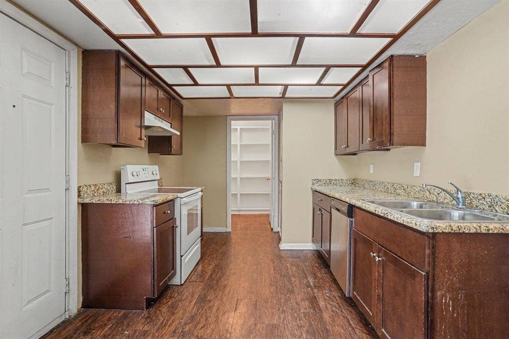 1414 Finley Road, Irving, TX 75062 Kitchen featuring wood-finish flooring, wood cabinetry, stone countertops, and a double basin sink
