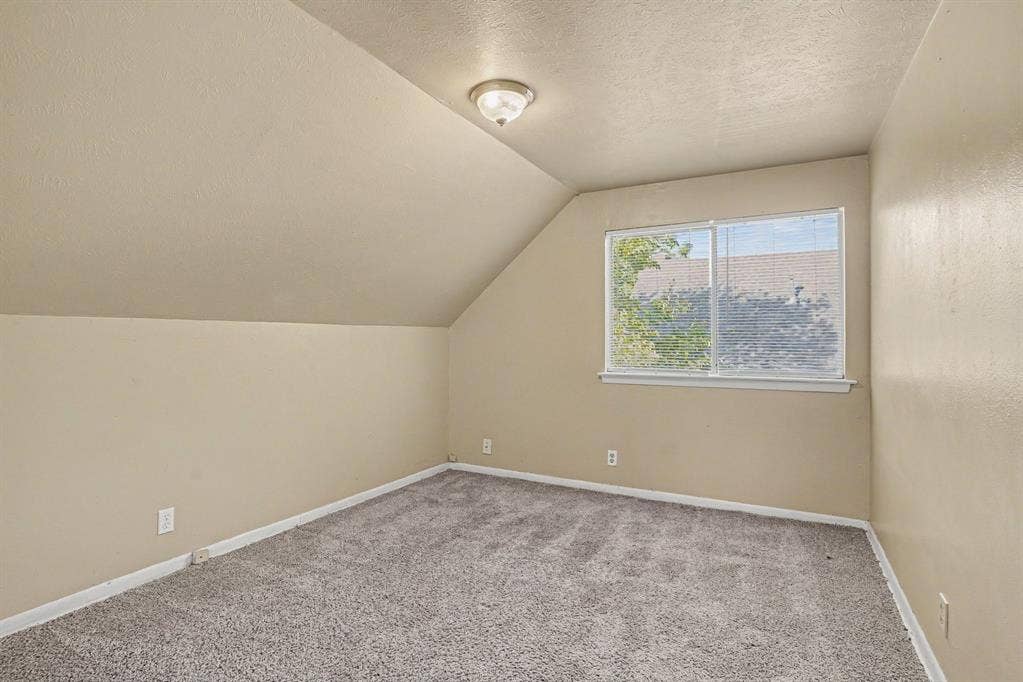 1414 Finley Road, Irving, TX 75062 Sloped ceiling room featuring carpet flooring and a window with blinds