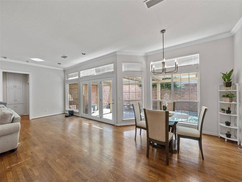 8640 Breakers Point, Dallas, TX 75243 Hardwood flooring throughout, with a bay window dining area and a modern chandelier