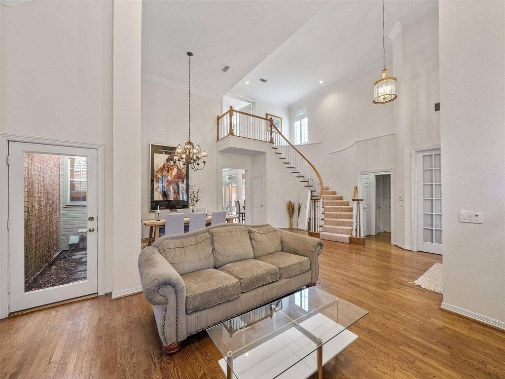 8640 Breakers Point, Dallas, TX 75243 Hardwood flooring throughout the main level, grand curved staircase, double-height ceilings, and a glass-paned exterior door