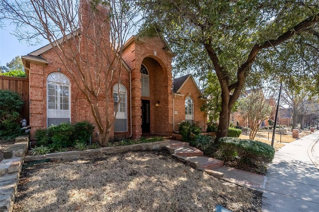 8640 Breakers Point, Dallas, TX 75243 Brick exterior featuring arched windows and a prominent chimney