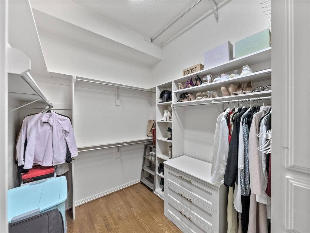 8640 Breakers Point, Dallas, TX 75243 Custom closet system featuring built-in shelving, multiple hanging rods, and a three-drawer storage unit