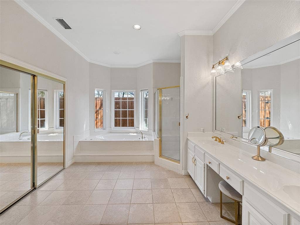 8640 Breakers Point, Dallas, TX 75243 Spacious bathroom featuring an expansive vanity with double sinks, a built-in soaking tub, a separate glass-enclosed shower, and tile flooring