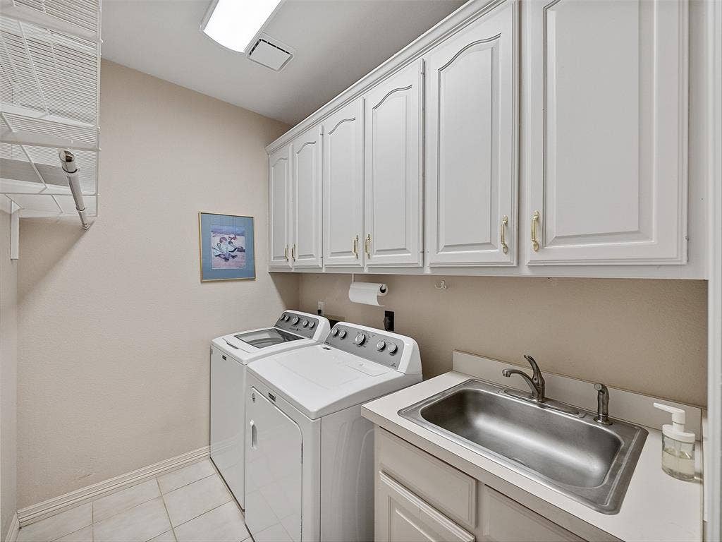 8640 Breakers Point, Dallas, TX 75243 Utility room featuring extensive upper cabinetry, a stainless steel sink with a single-handle faucet, and built-in counter space