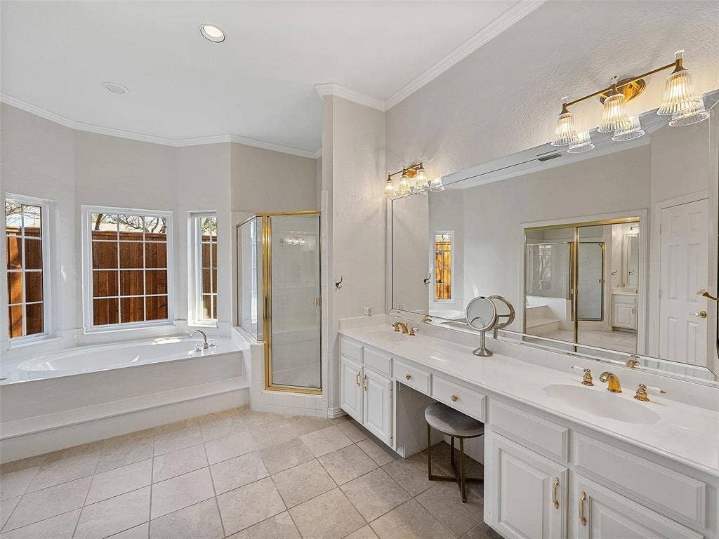 8640 Breakers Point, Dallas, TX 75243 Spacious bathroom featuring a dual vanity, built-in soaking tub, separate glass-enclosed shower, and tile flooring