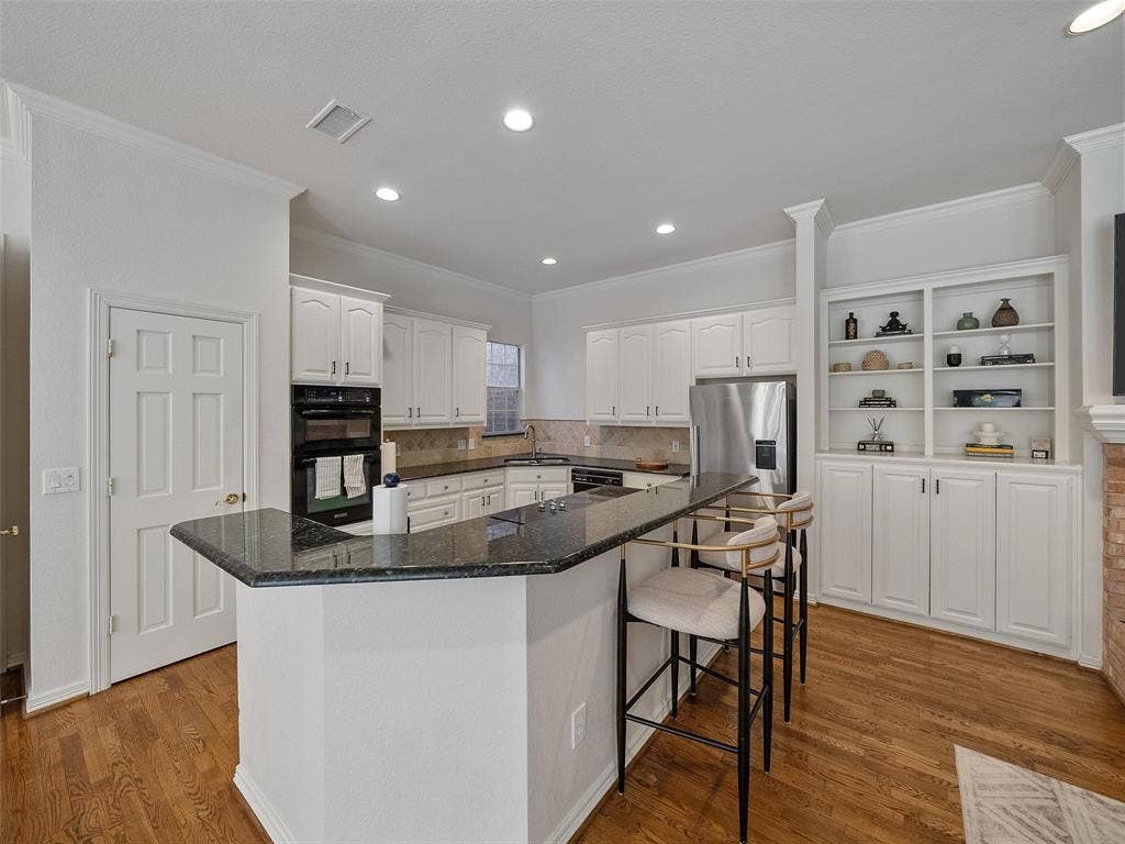8640 Breakers Point, Dallas, TX 75243 Hardwood-finish flooring, built-in shelving, stainless steel appliances, granite countertops, and white cabinetry