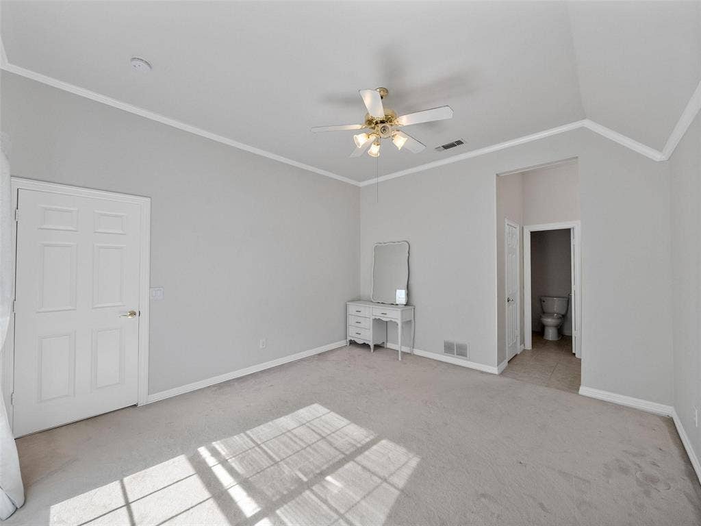 8640 Breakers Point, Dallas, TX 75243 Vaulted ceiling, ceiling fan, carpet flooring, panel doors, and tile flooring in the adjacent area