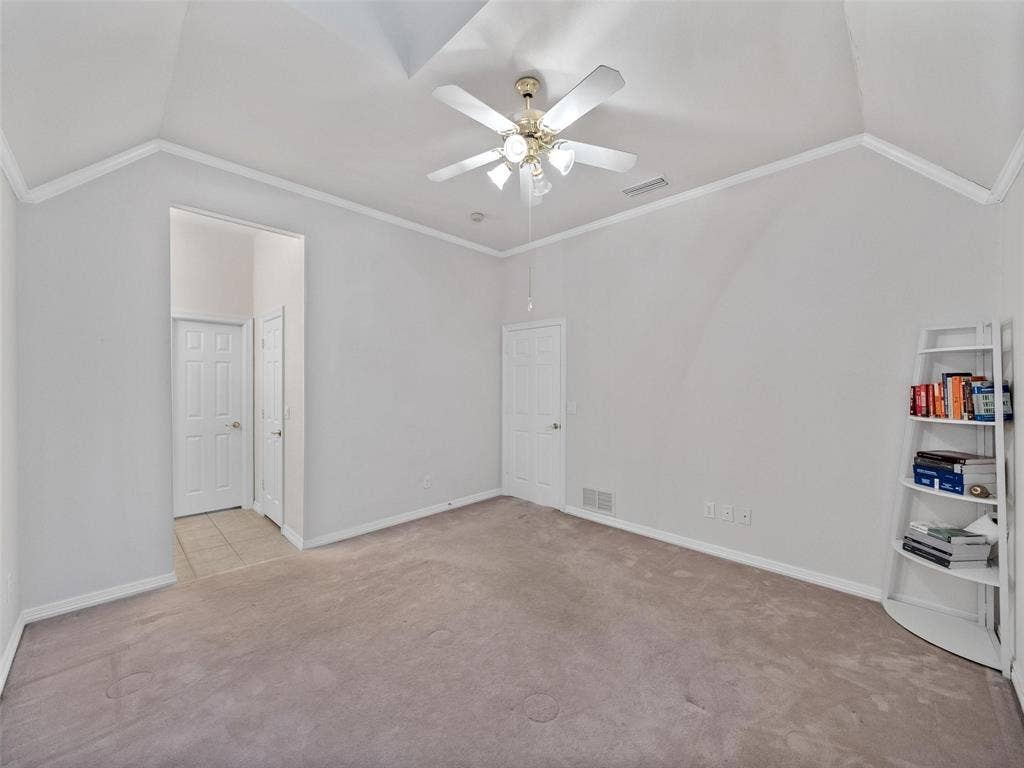 8640 Breakers Point, Dallas, TX 75243 Vaulted ceiling with crown molding, ceiling fan with integrated lighting, carpeted flooring, and white paneled doors