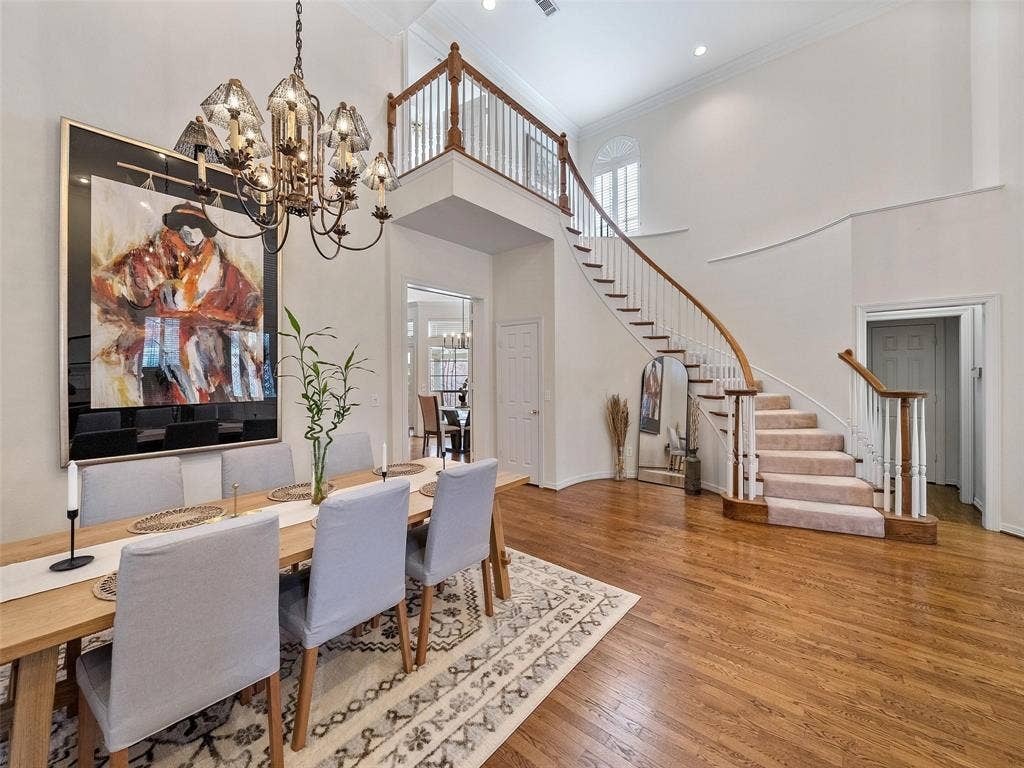 8640 Breakers Point, Dallas, TX 75243 Hardwood flooring and a curved staircase with carpeted treads
