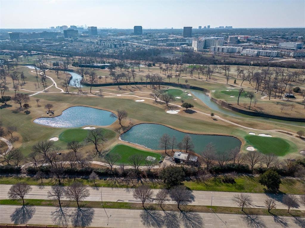 8640 Breakers Point, Dallas, TX 75243 Golf course with multiple water features, green fairways, and distant urban skyline