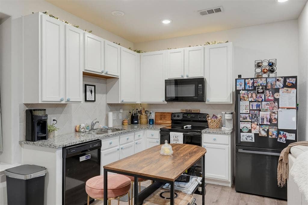 5525 Willamette Drive, Fort Worth, TX 76119 White cabinetry, granite countertops, black appliances, tile backsplash, and recessed lighting