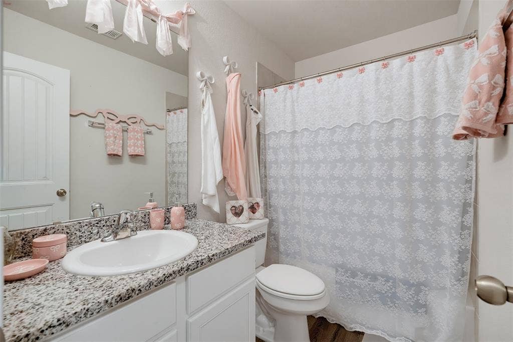 5525 Willamette Drive, Fort Worth, TX 76119 Bathroom featuring a single vanity with a granite countertop, undermount sink, and chrome faucet